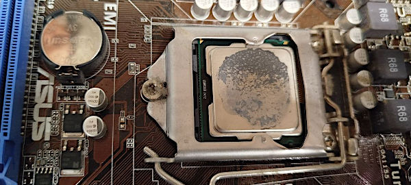 Lo strato ormai secco della pasta termoconduttiva sulla CPU Lo strato ormai secco della pasta termoconduttiva sulla CPU