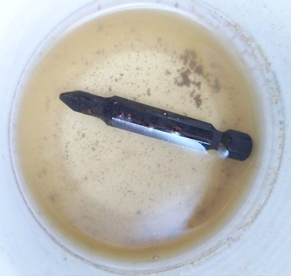 L'innesto Pozidriv immerso nell'aceto dopo 24 ore: si vede la ruggine staccata dal metallo